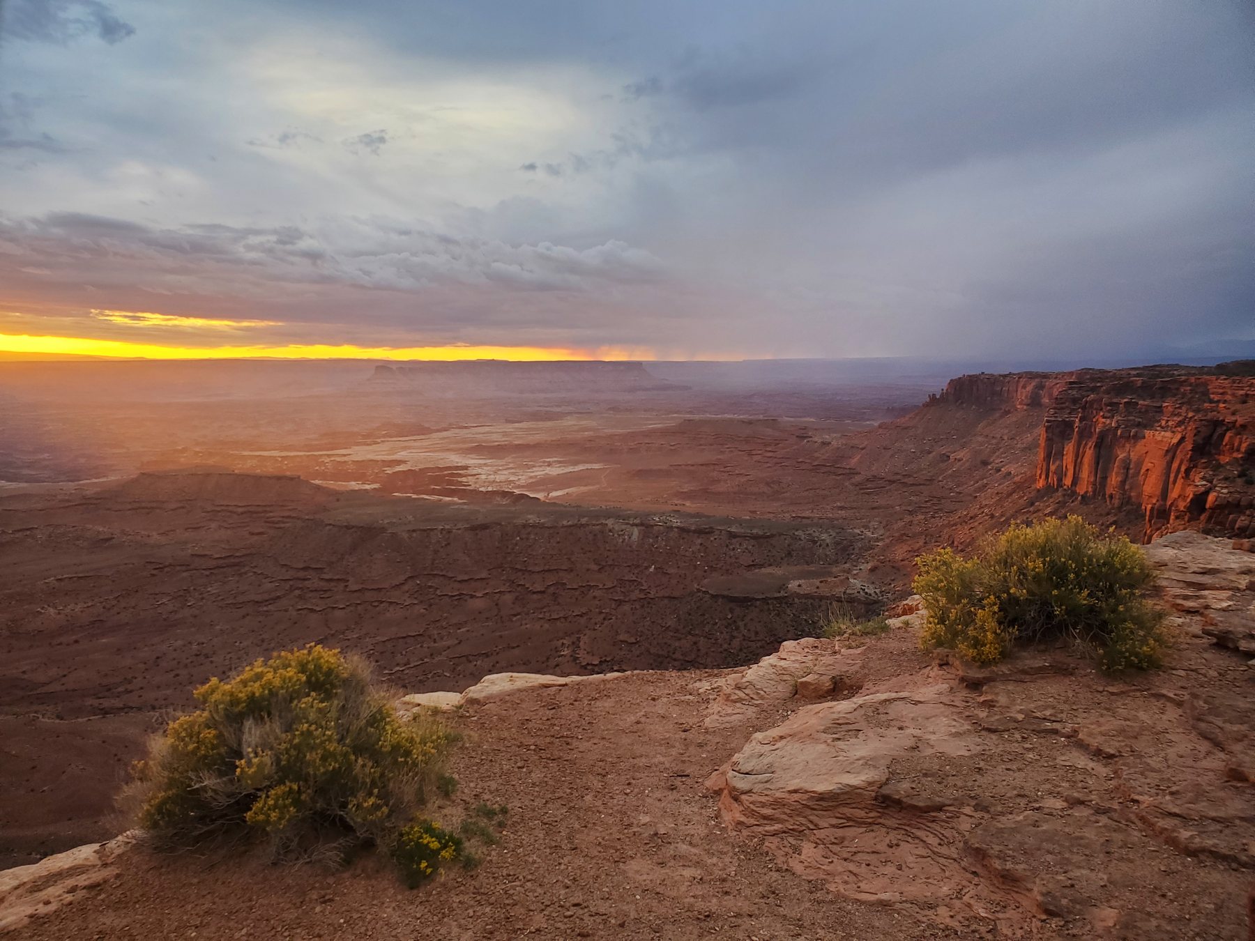 A storm opening over a broad canyon rim